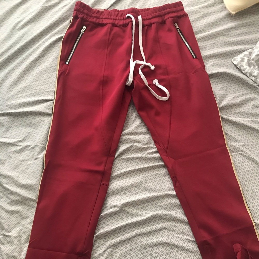 Men’s red striped jogger track pants. Elastic waistband with draw cord.